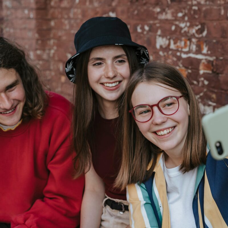 Teenagers taking group selfie